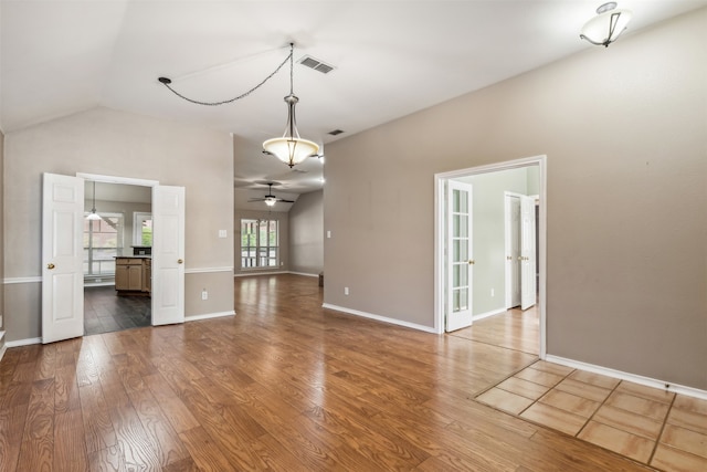 unfurnished living room with lofted ceiling, wood-type flooring, and ceiling fan