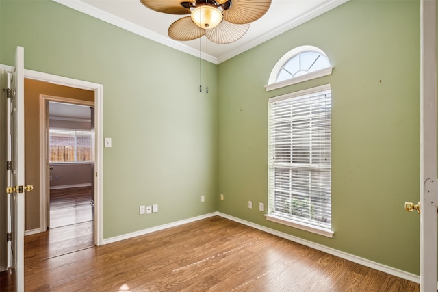 empty room featuring light hardwood / wood-style floors, crown molding, and ceiling fan