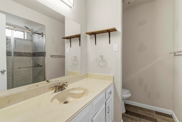 bathroom featuring wood-type flooring, toilet, a shower with door, and vanity