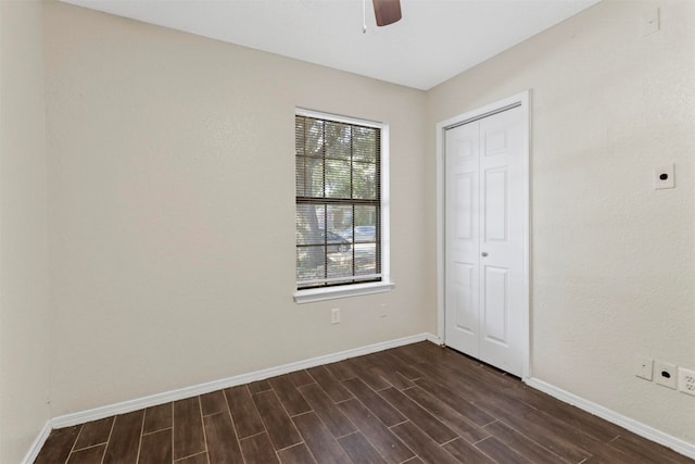 unfurnished bedroom with dark wood-type flooring, ceiling fan, and multiple windows