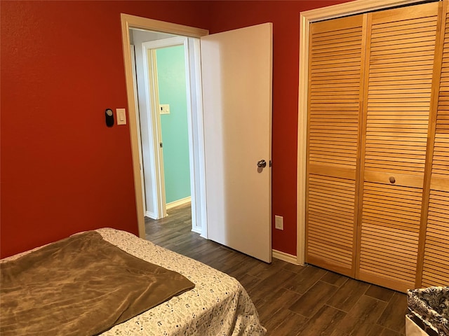 bedroom with dark hardwood / wood-style flooring and a closet