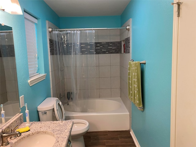 full bathroom featuring tiled shower / bath, toilet, hardwood / wood-style flooring, and vanity