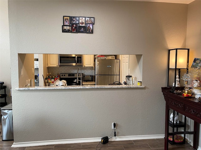 kitchen featuring appliances with stainless steel finishes, decorative backsplash, and dark hardwood / wood-style floors