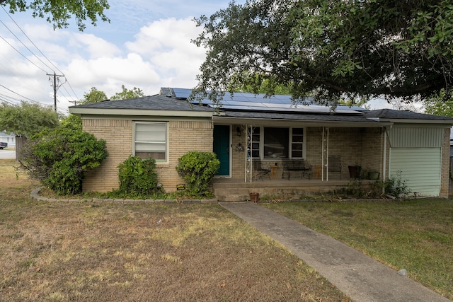 view of front of home with solar panels, covered porch, and a front lawn