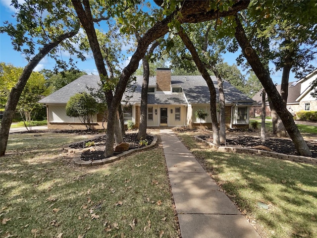 view of front facade featuring a chimney and a front lawn