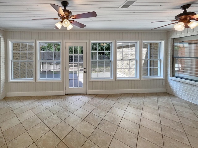 unfurnished sunroom featuring ceiling fan