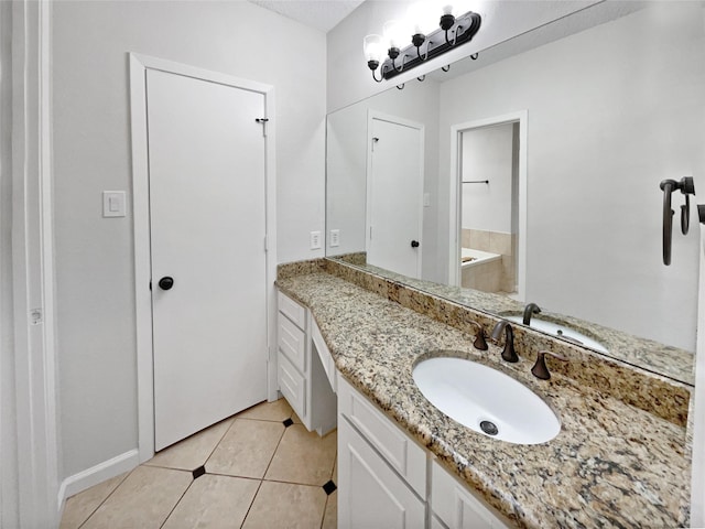 bathroom with a tub, vanity, and tile patterned floors