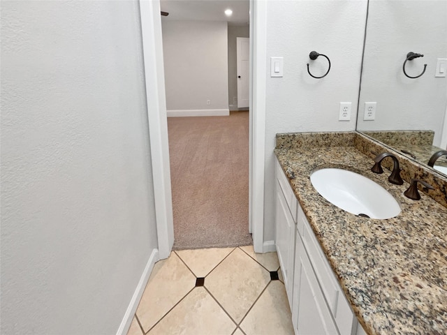 bathroom with baseboards, vanity, and tile patterned floors