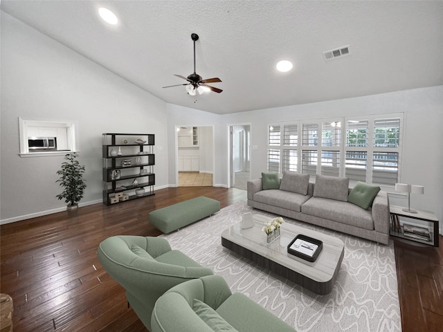 living room with lofted ceiling, ceiling fan, dark hardwood / wood-style flooring, and a textured ceiling