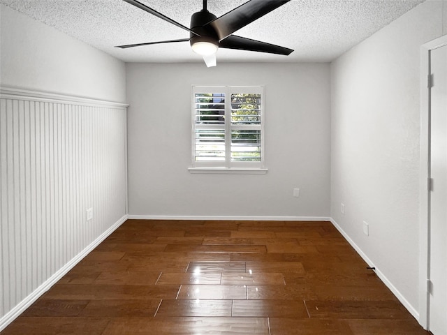 empty room featuring ceiling fan, a textured ceiling, hardwood / wood-style flooring, and baseboards