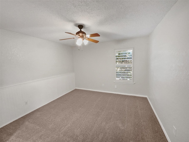 carpeted empty room with ceiling fan and a textured ceiling