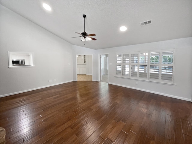 unfurnished living room with lofted ceiling, ceiling fan, dark hardwood / wood-style floors, and a textured ceiling