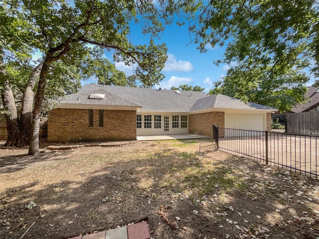 ranch-style home featuring concrete driveway, a patio, an attached garage, fence, and brick siding