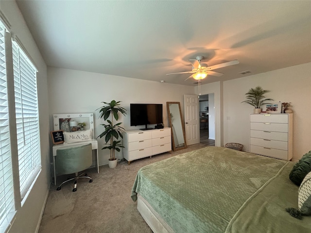 carpeted bedroom featuring ceiling fan and multiple windows