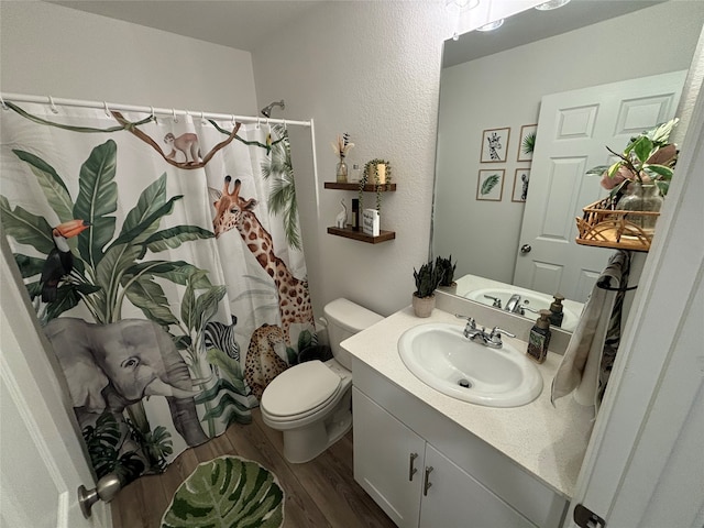 bathroom featuring curtained shower, hardwood / wood-style floors, toilet, and vanity