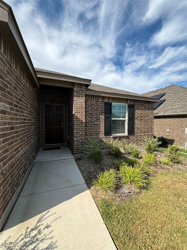 doorway to property with a yard