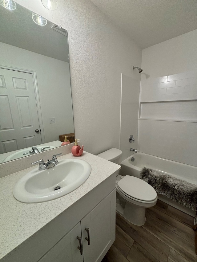 full bathroom featuring vanity, toilet, wood-type flooring, and washtub / shower combination