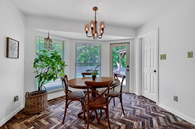 dining room with dark parquet floors and a chandelier