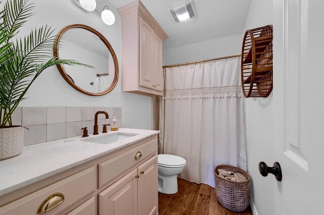 bathroom featuring a shower with shower curtain, toilet, wood-type flooring, decorative backsplash, and vanity