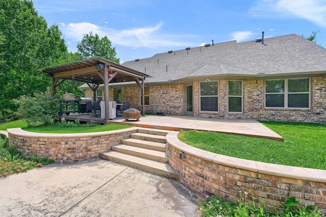 back of property with a patio area, roof with shingles, and brick siding