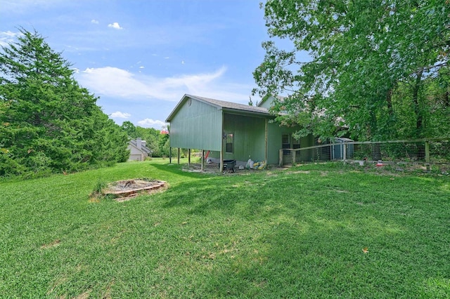 view of yard with a pole building, an outdoor structure, and fence