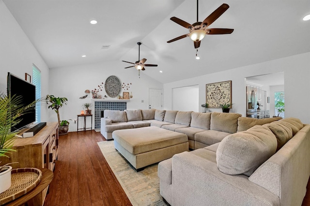 living area featuring a tile fireplace, recessed lighting, wood finished floors, visible vents, and vaulted ceiling