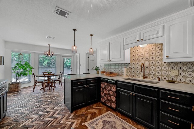 kitchen featuring white cabinets, an inviting chandelier, dishwashing machine, sink, and dark parquet flooring