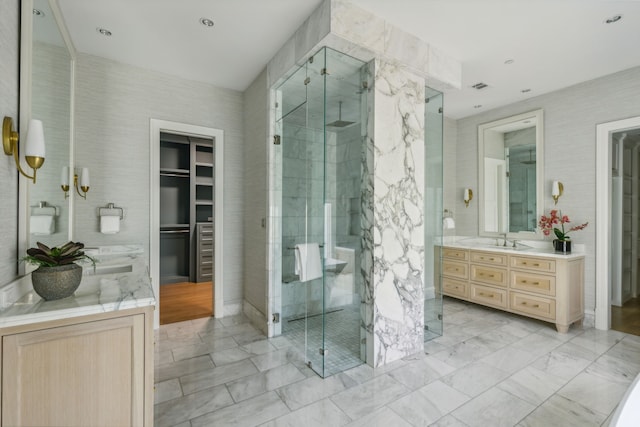 bathroom with a shower with door and vanity