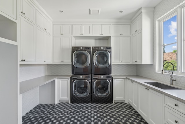 laundry area with cabinets, sink, independent washer and dryer, and stacked washer and clothes dryer