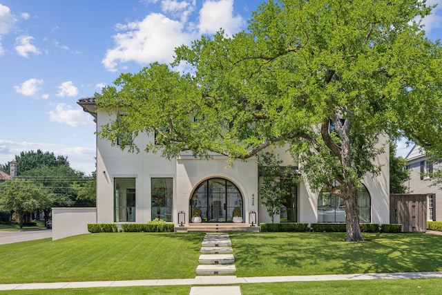 mediterranean / spanish house featuring french doors and a front lawn