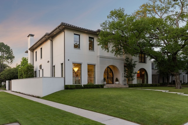 mediterranean / spanish home with a lawn