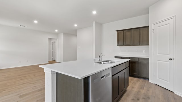 kitchen featuring dark brown cabinetry, sink, stainless steel dishwasher, light hardwood / wood-style flooring, and a center island with sink