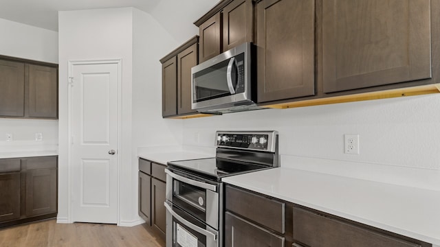 kitchen featuring appliances with stainless steel finishes, dark brown cabinets, and light hardwood / wood-style flooring