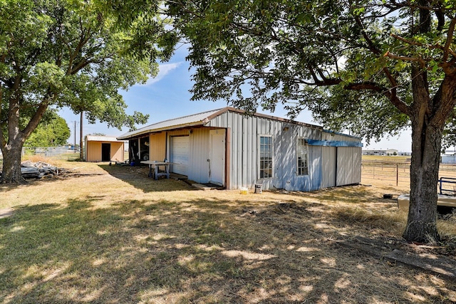 rear view of property featuring an outdoor structure