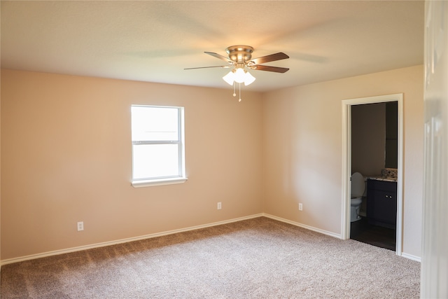 unfurnished bedroom with carpet flooring, ceiling fan, and ensuite bath