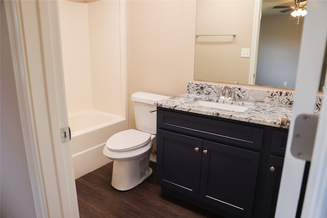 full bathroom with toilet, hardwood / wood-style floors, vanity, ceiling fan, and bathing tub / shower combination