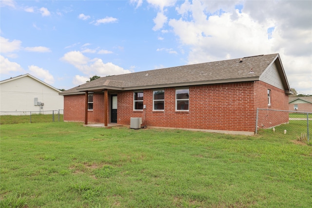 rear view of house featuring a yard and central AC unit