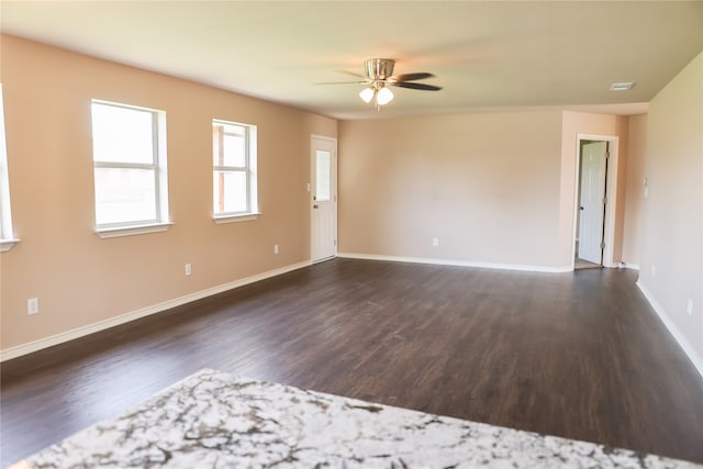 unfurnished room featuring dark wood-type flooring and ceiling fan