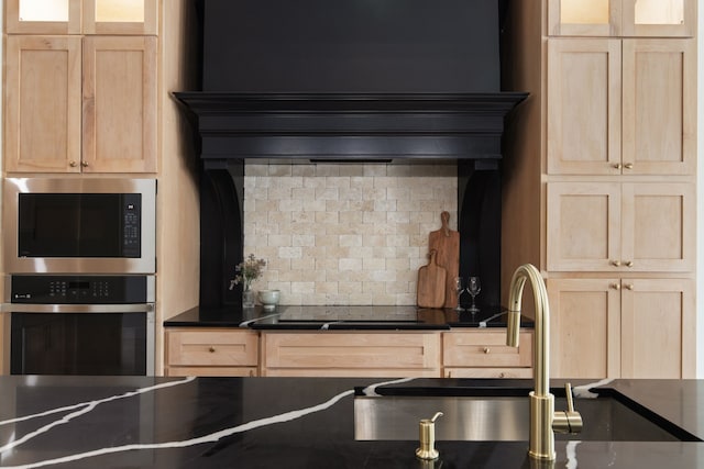 kitchen with stainless steel appliances, sink, light brown cabinets, and tasteful backsplash