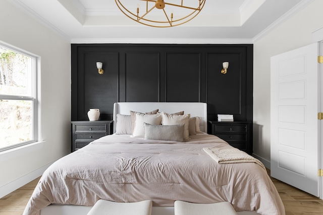 bedroom with crown molding, a raised ceiling, and multiple windows