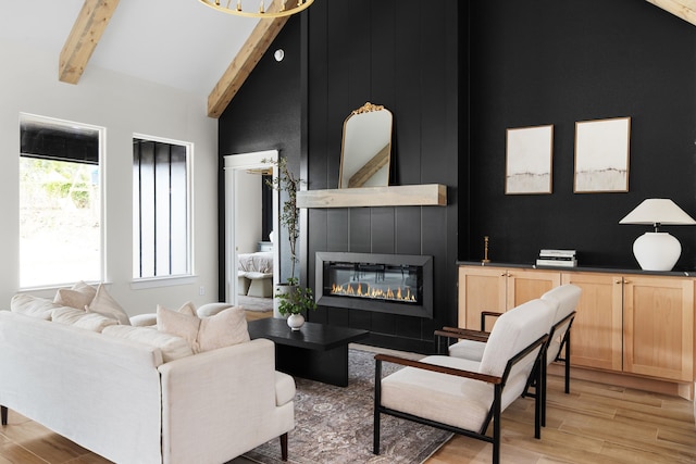 living room featuring high vaulted ceiling, a fireplace, beamed ceiling, and light hardwood / wood-style flooring