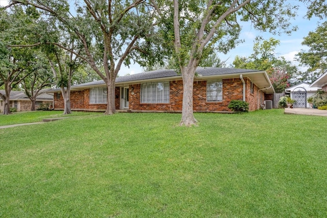 single story home featuring a garage, a front yard, and cooling unit