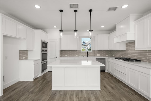 kitchen featuring appliances with stainless steel finishes, dark hardwood / wood-style flooring, and white cabinetry