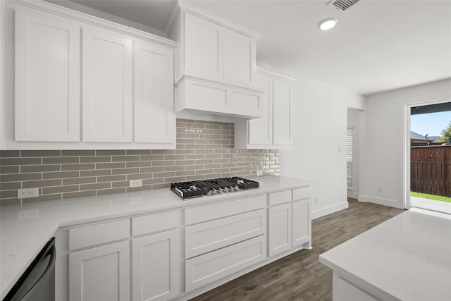 kitchen featuring light stone counters, backsplash, dark wood-type flooring, white cabinetry, and stainless steel appliances