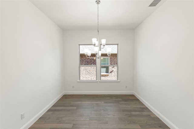 unfurnished dining area with dark hardwood / wood-style floors and a notable chandelier