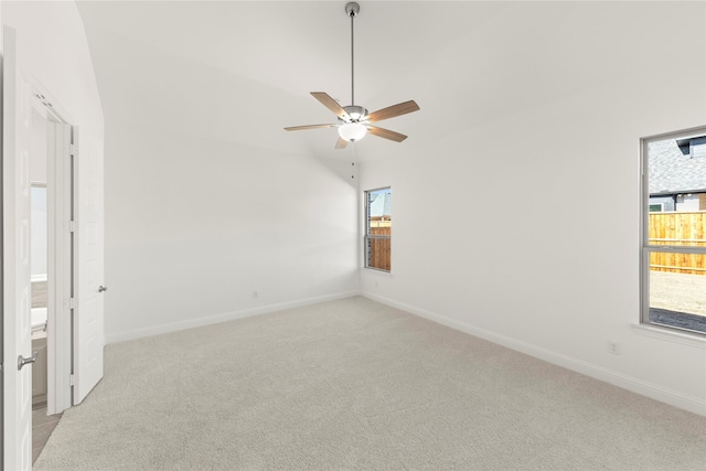 unfurnished room with ceiling fan, vaulted ceiling, and light carpet