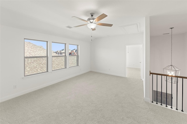 carpeted empty room with ceiling fan with notable chandelier