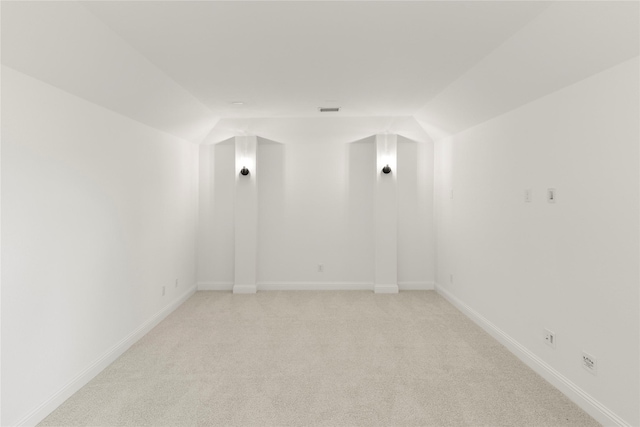 carpeted spare room with lofted ceiling