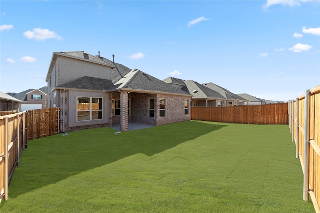 rear view of property featuring a yard and a patio area