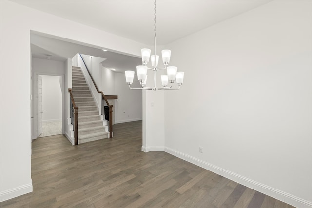 unfurnished dining area featuring dark hardwood / wood-style floors and a chandelier